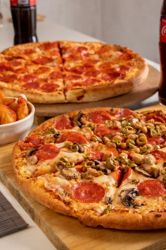 Freshly baked pizzas with vegetables and mushrooms